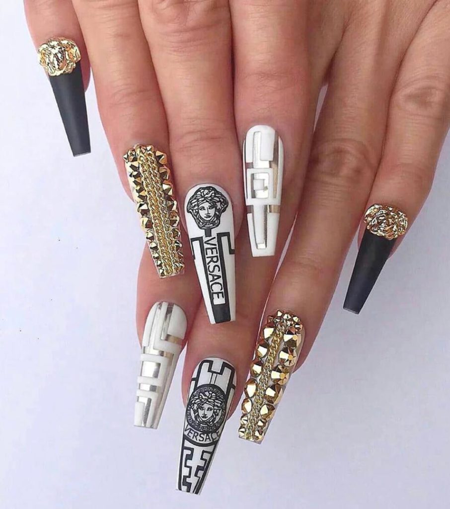 Nail artist använder VERSACE LOGO nagelklistermärken på vita naglar. Supersnygga nail stickers nageldekorationer Nail decoration Modemärken